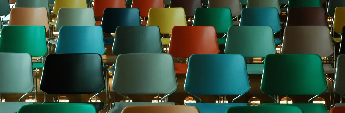Rangées de chaises colorées disposées pour une assemblée